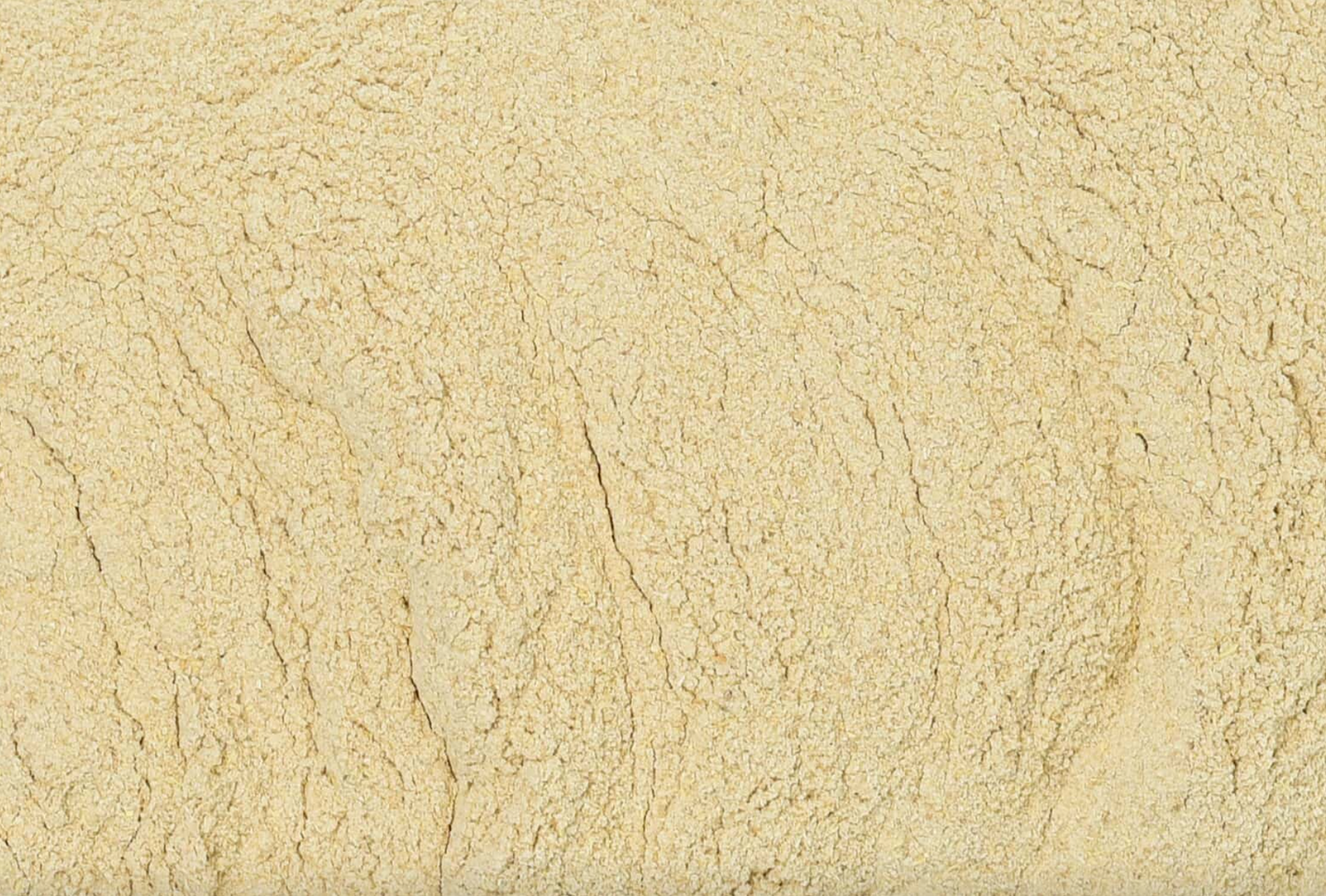 Close-up texture of dried ashwagandha root powder, showing fine beige powder used for teas and herbal remedies.