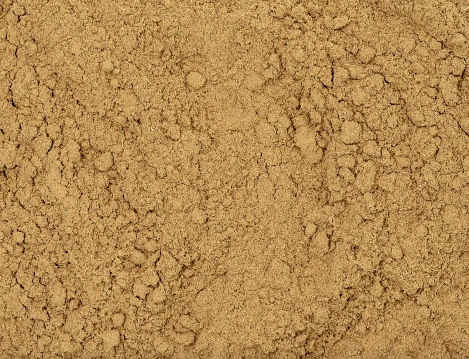 Close-up of dried licorice root powder, showing fine brown powder used for teas and herbal remedies.